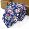 Nœud de coton floral élégant roulé avec des fleurs roses et vertes sur fond bleu.