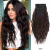 Una mujer con largo cabello oscuro y ondulado vistiendo una blusa blanca, junto a un paquete de extensiones de cabello de cli