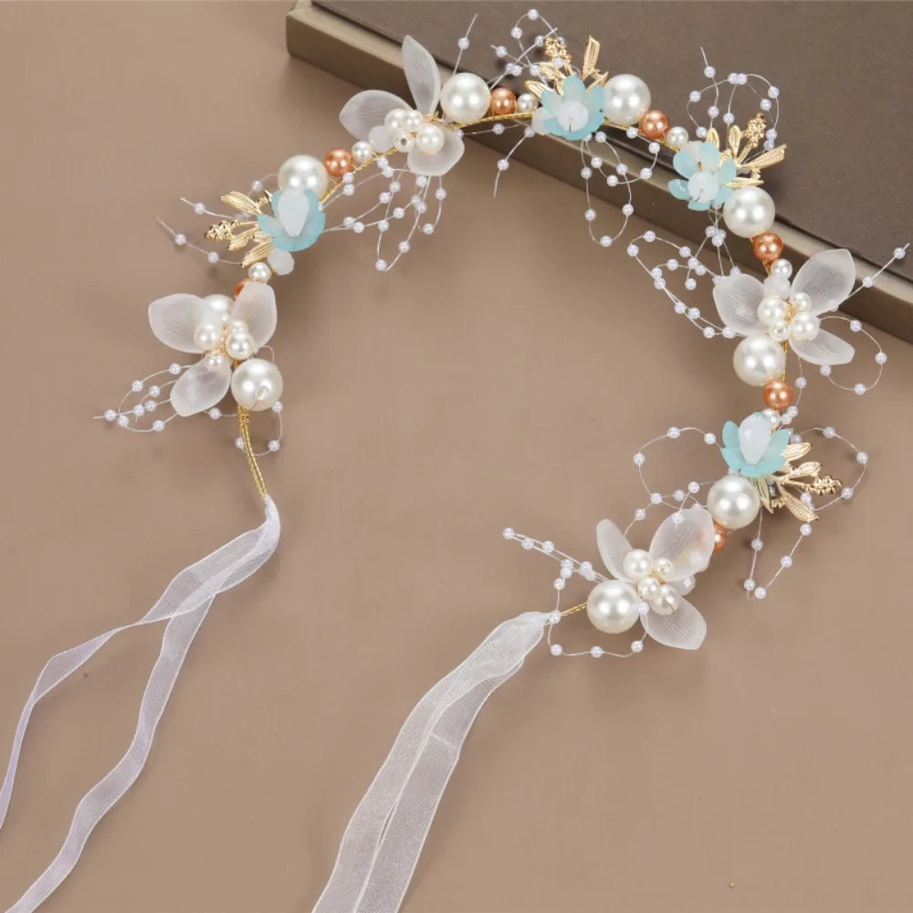 Elegant floral wreath headband featuring white and light blue flowers and pearl accents