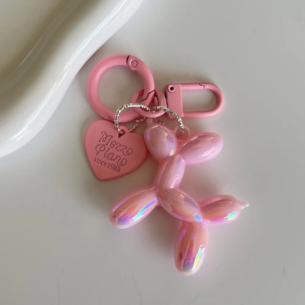A pink jelly cartoon dog keychain with a heart tag and silver chain.