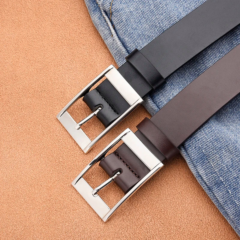 A close-up of a dark brown PU leather belt with a silver metal pin buckle resting on a denim fabric background.