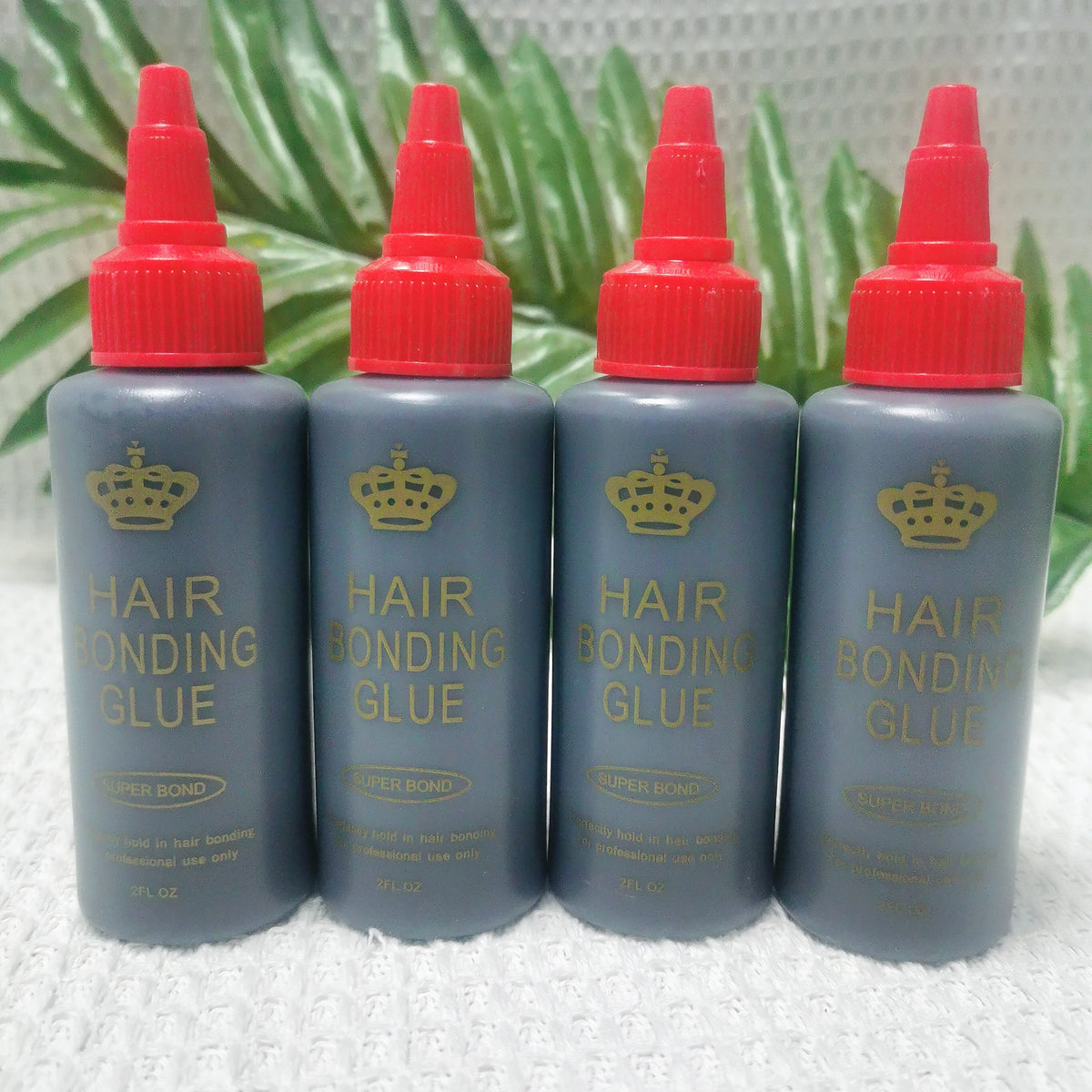 Four bottles of professional hair bonding glue in gray and red caps are displayed against a green leaf background.