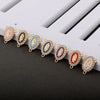 A line of gold-toned rosary connectors featuring colorful, oval-shaped enamel designs.