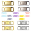 A collection of gold and silver metal shoe charms and laces with various finishes and designs.