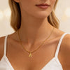 A gold plated initial letter necklace with an 'A' charm worn by a woman.