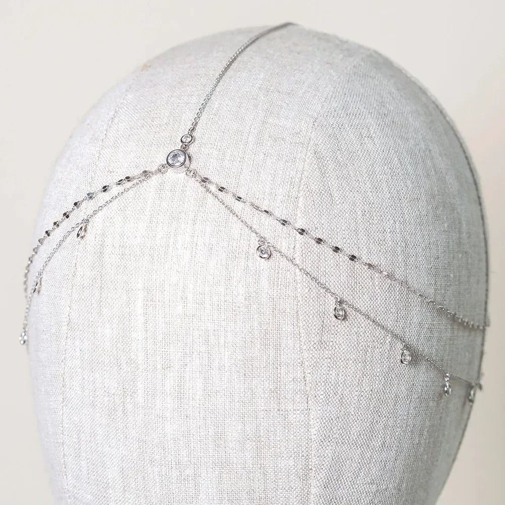 A delicate silver crystal head chain for bridal hair accessories displayed on a mannequin.