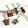 A set of alphabet letter acrylic keychains featuring various animal figures and a pink butterfly tassel.
