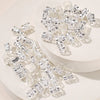 A collection of clear, faceted metal hair rings and clips displayed on a white surface.