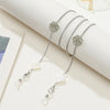 Silver metal eyeglass chain featuring a floral pendant and pearl accents
