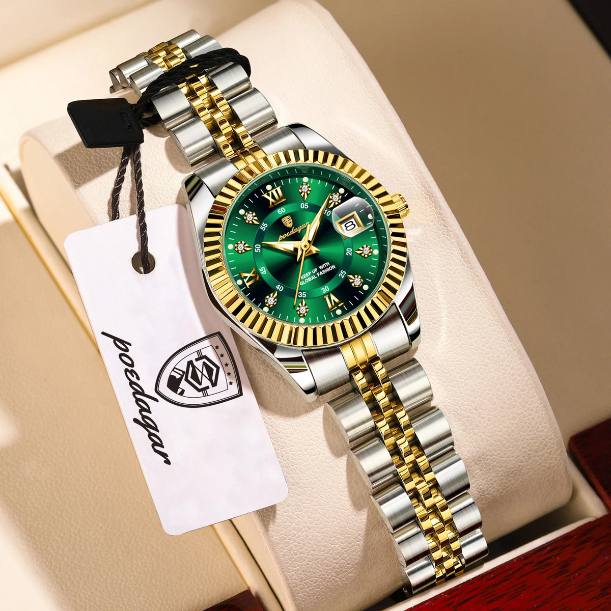 A silver and gold watch set with luminous hands and date display resting on a light-colored surface.
