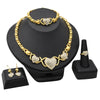 A gold heart crystal jewelry set featuring a necklace and ring displayed on a black stand.