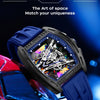 A close-up of a blue and black luxury watch with a complex dial resting on a red sports car.