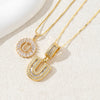 Gold-toned necklace set featuring CZ crystal pendants shaped like the letters U and a circular design.