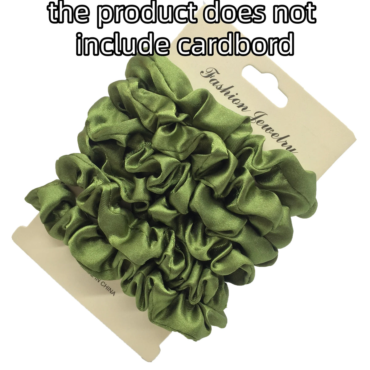 A pile of olive green satin fabric gathered into ruffled hair scrunchies, displayed on a cardboard tag.