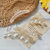 A set of simulated pearl hair claws displayed on a piece of parchment paper next to a woven basket.