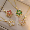 Colliers pendentifs de quatre fleurs en or avec des pierres zircons roses, vertes et blanches.