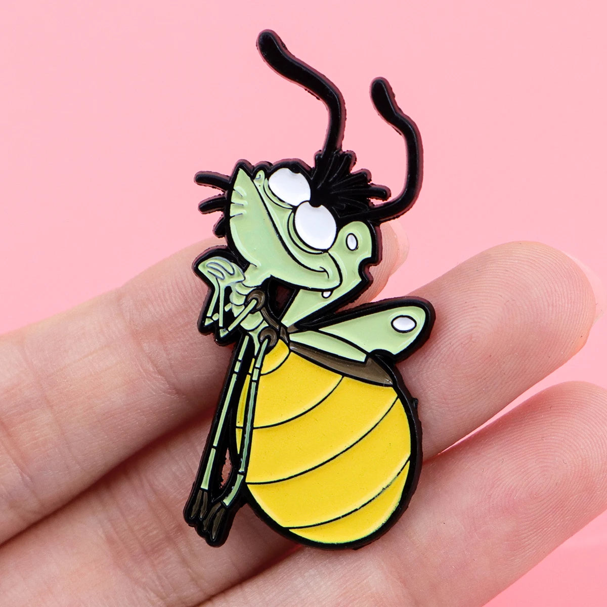 A cute firefly enamel pin brooch shaped like a frog with green skin and yellow wings