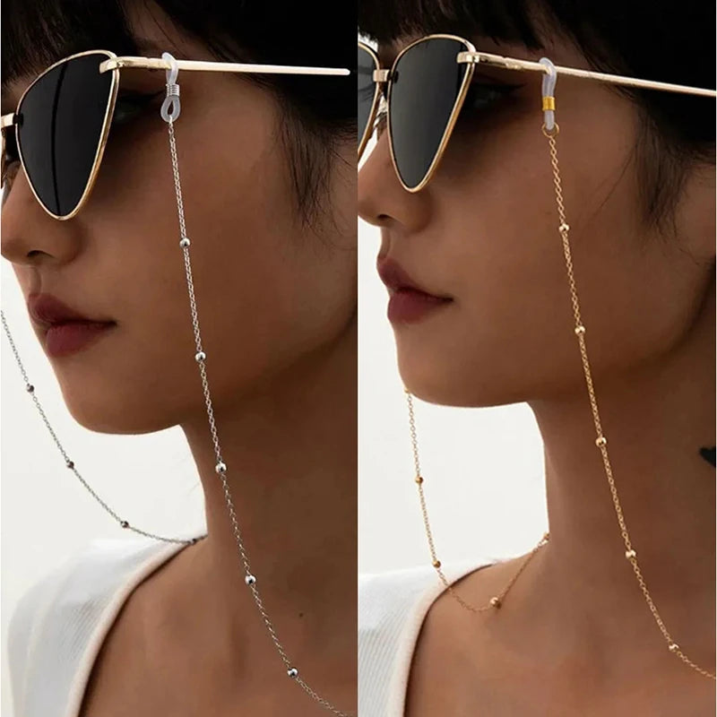 Close-up of a woman wearing round metal beads sunglasses with a delicate gold chain detail