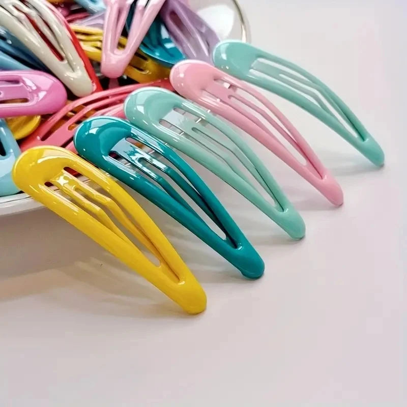 Una colección de pinzas para el cabello de plástico coloridas en varios tonos, incluyendo rosa, amarillo, azul y verde.