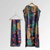 A long, dark purple floral butterfly peacock cape shawl hanging on a wooden hanger.