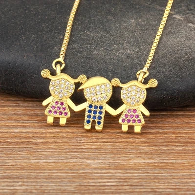 Collier délicat couleur or avec trois petits charms de femmes et pierres scintillantes.