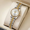 A silver and gold rhinestone quartz wristwatch is displayed on a light-colored box.