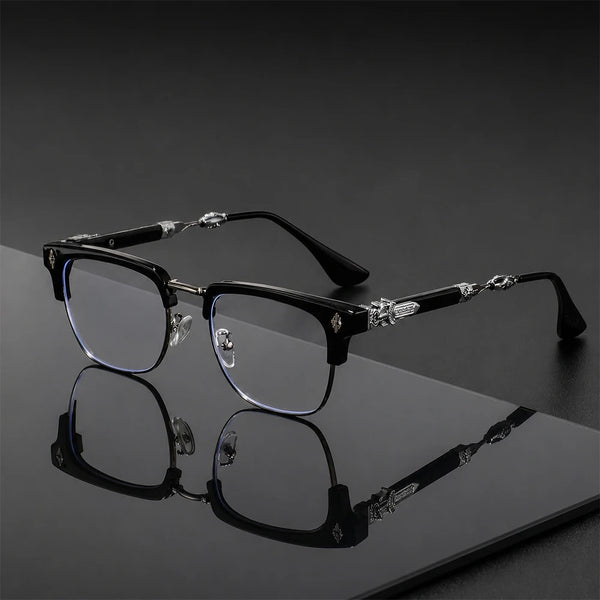 A pair of black vintage half-rim eyeglasses with clear lenses and decorative crystal accents resting on a dark surface.