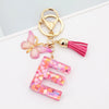 Alphabet letter E acrylic keychain with a pink butterfly charm and a pink tassel