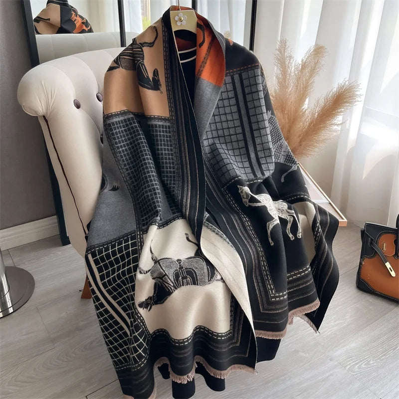 A luxury plaid cashmere feel scarf and shawl wrap in shades of black, gray, beige, and burnt orange draped over a white chair