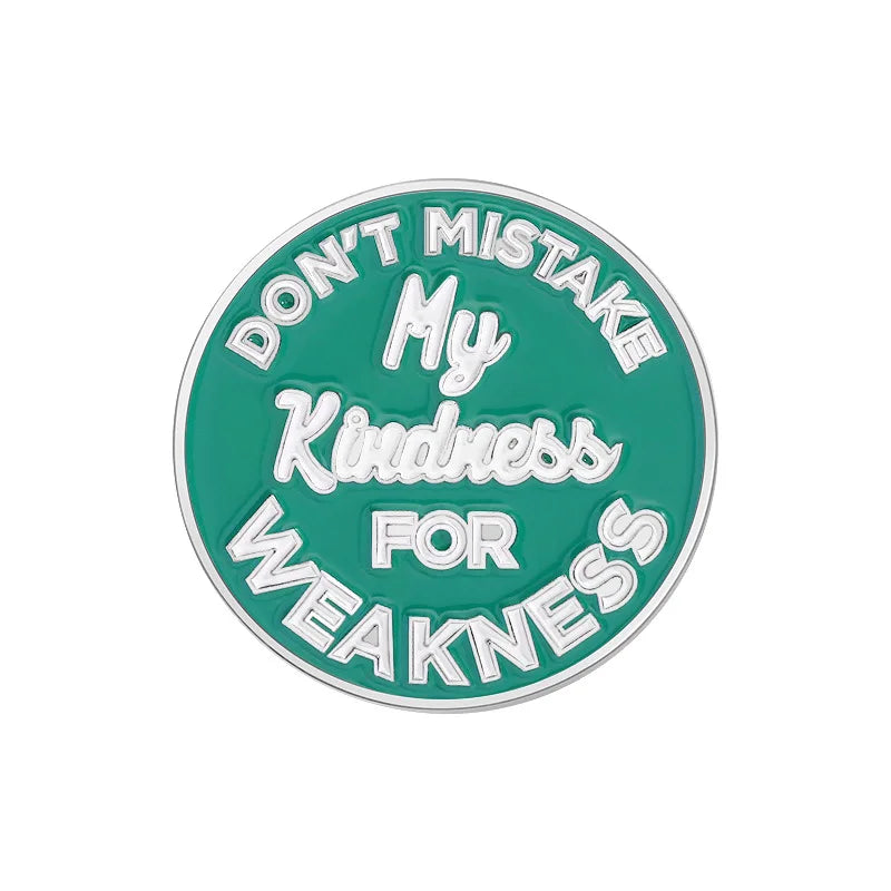 A round enamel lapel pin with the text Don't Mistake My Kindness for Weakness in white lettering on a teal background.