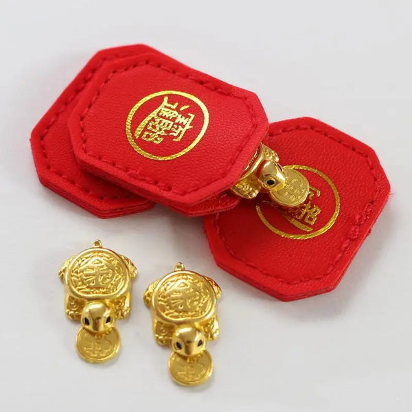 Red felt tags with gold emblems and small gold turtle charms for longevity and financial stability