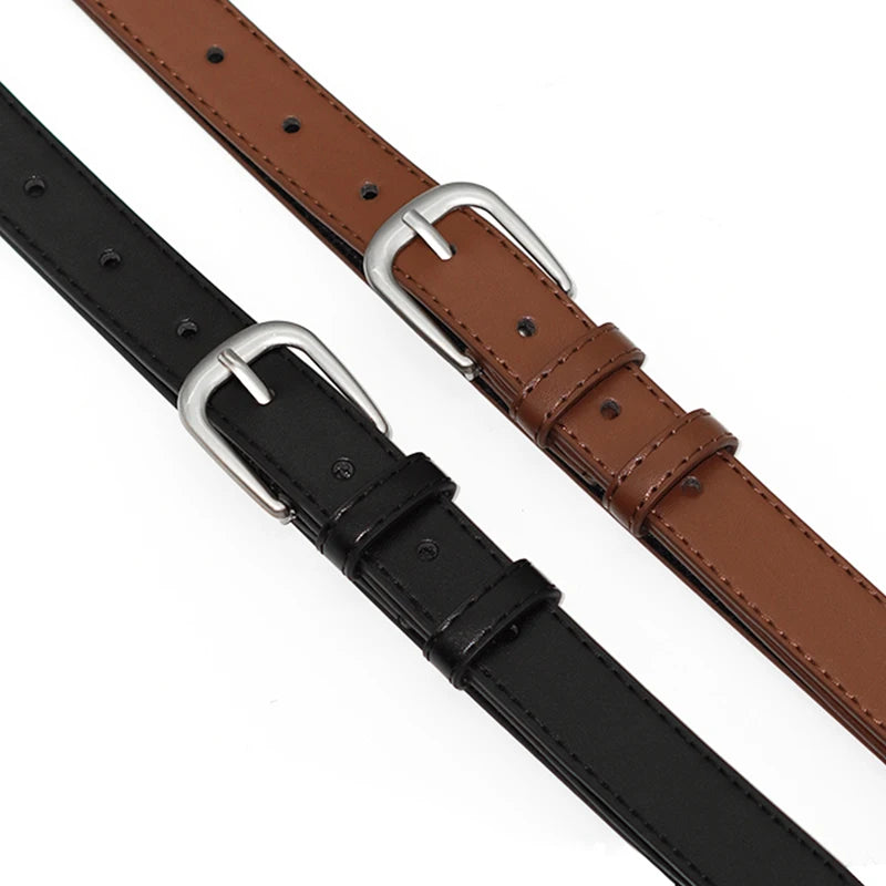 A close-up of a brown leather belt and a black leather belt with silver buckles.