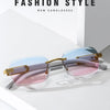 A pair of gradient sunglasses with pink and blue lenses and gold accents displayed on a white surface.