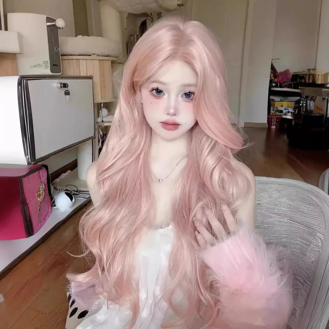 Una mujer con una peluca de cabello sintético rosa rosa largo y fluido está sentada en interiores.