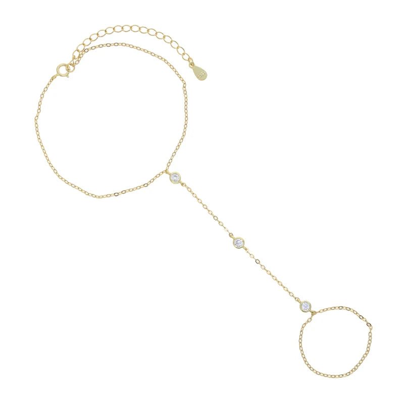 A delicate gold-toned geometric bezel charm bracelet with a chain and various charms.