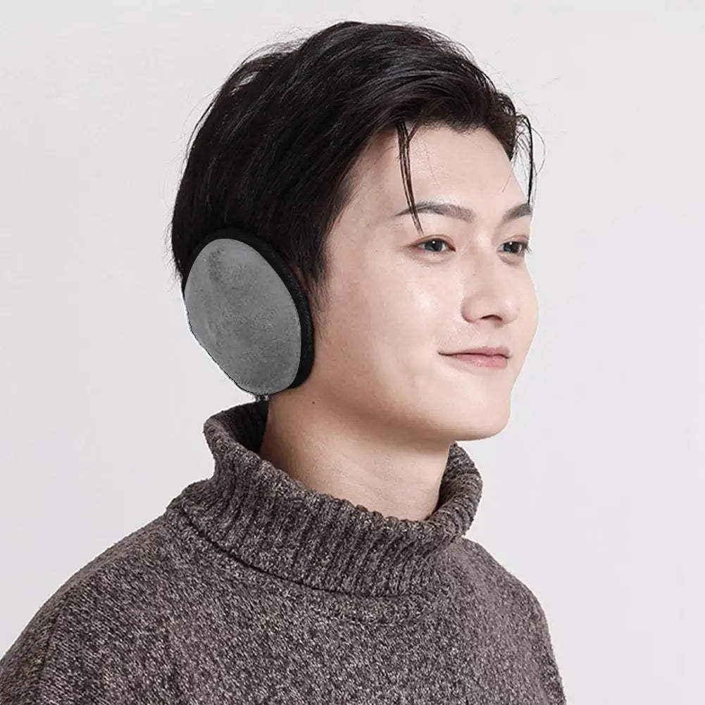 A close-up of a man wearing gray plush winter earmuffs while looking to the side.