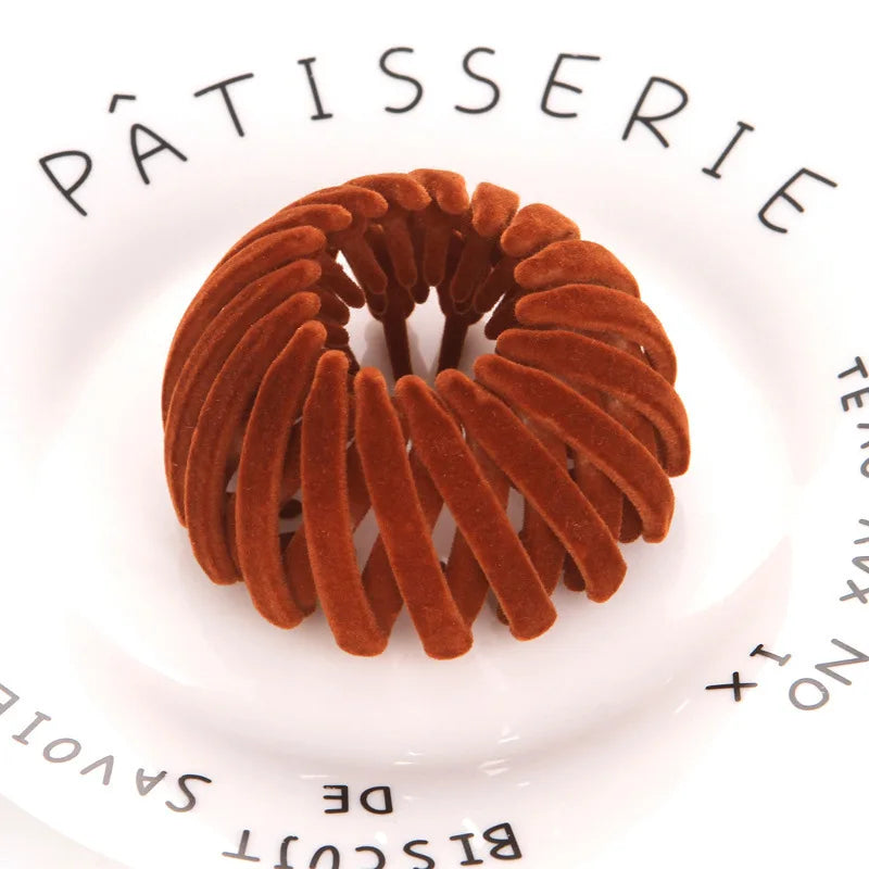 A circular arrangement of brown, textured hair clips resembling horsetail braids on a white plate.