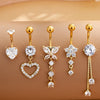 A set of five gold stainless steel dangled belly button rings featuring clear and white stones.