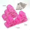 Pink heatless hair curlers in various sizes and a set of metal curling rods