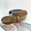 A vintage PU leather boho western belt in brown leather with embossed floral patterns.