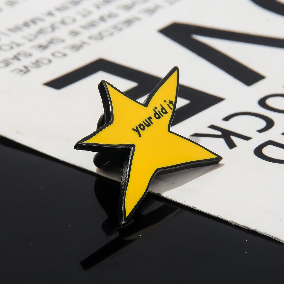 A yellow star enamel pin brooch with the text you did it on a white background.
