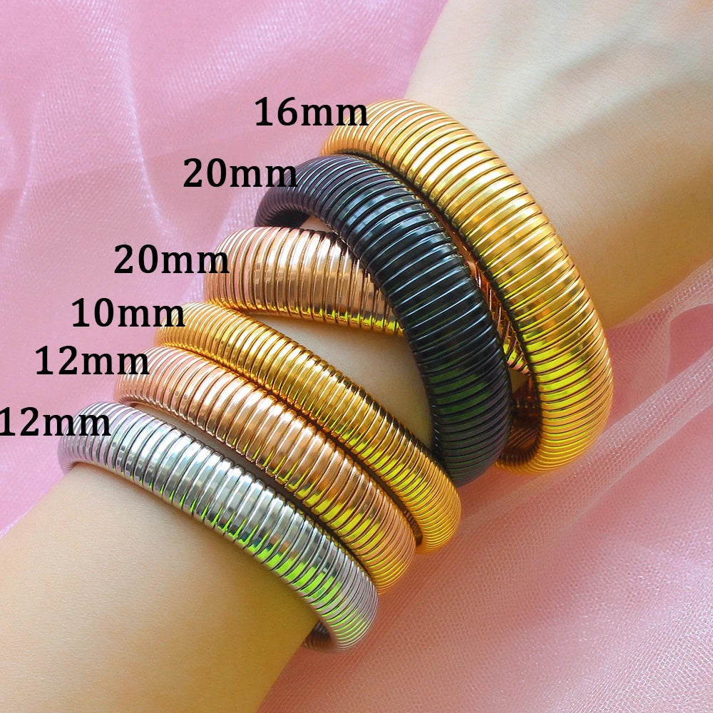 A collection of stacked gold and silver elastic bangle bracelets with varying diameters, shown on a light skin tone arm.