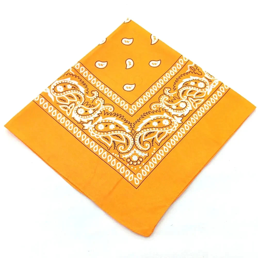 Orange fabric bandana featuring white paisley and geometric patterns for a headband or wrist wrap set