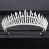 A brilliant diamond bridal crown with pointed spikes and intricate detailing displayed on a dark surface.