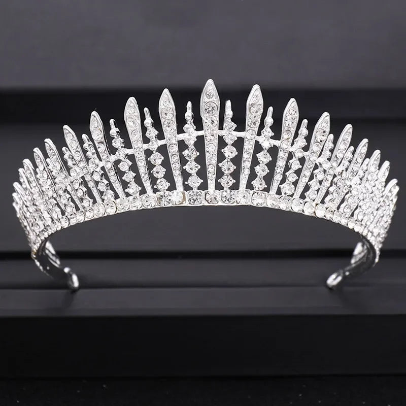 A brilliant diamond bridal crown with pointed spikes and intricate detailing displayed on a dark surface.