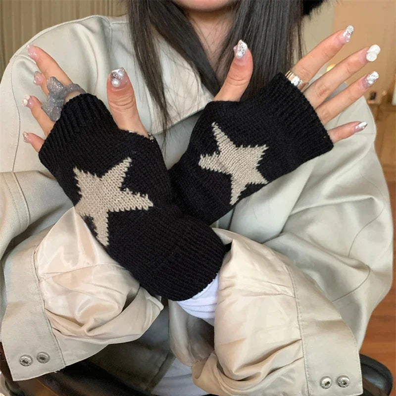 Una persona vistiendo ropa beige sostiene guantes sin dedos de punto negros con patrones de estrellas.