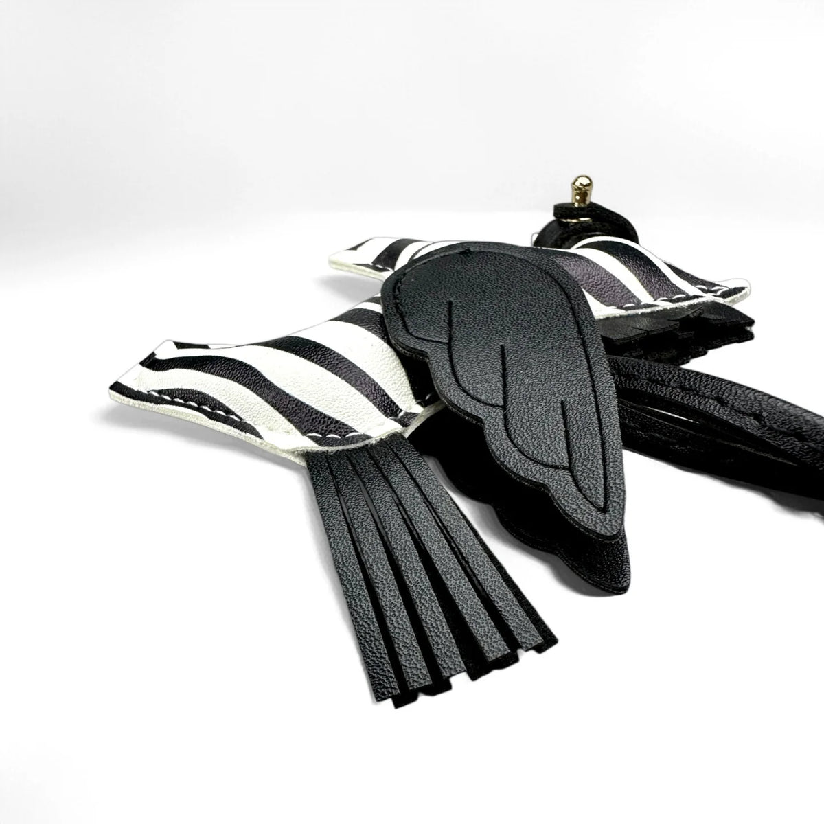 Black and white striped leather wings keychain with black tassels