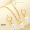 A gold-toned necklace and matching pearl earrings set displayed on a light background.