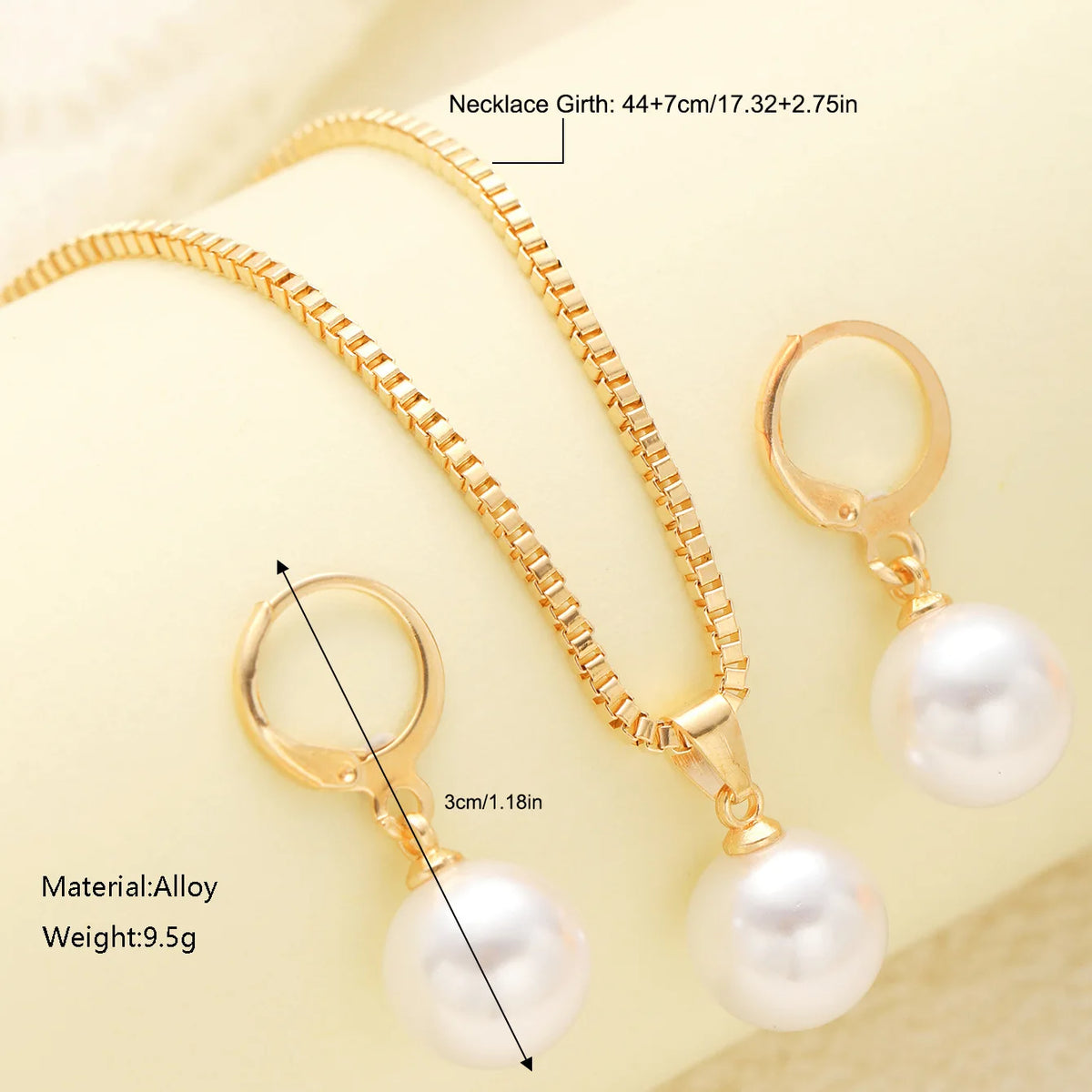 A gold-toned necklace and matching pearl earrings set displayed on a light background.