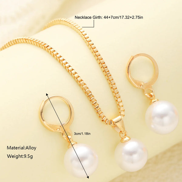 A gold-toned necklace and matching pearl earrings set displayed on a light background.
